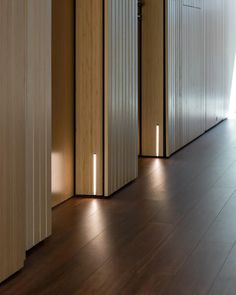 an empty room with wooden floors and white walls, lights on the side of the wall