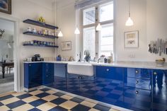 a kitchen with blue cabinets and checkered flooring