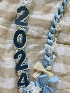 a blue and white ribbon necklace with the number twenty four on it's side