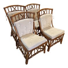 four bamboo chairs with white cushions and buttons on the back, set against a white background