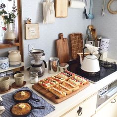 a kitchen counter topped with lots of food and cooking utensils on top of it