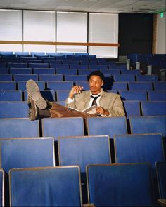 a man is sitting in the middle of an empty auditorium with his feet up on the floor