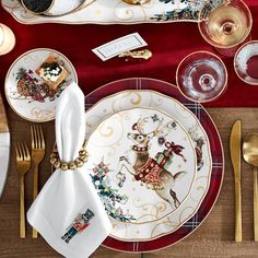 a table set for christmas with plates, silverware and napkins