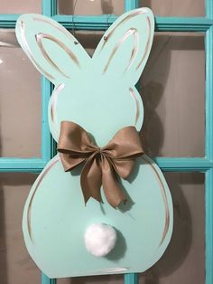 an easter bunny door hanger with a brown bow