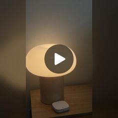 a lamp that is sitting on top of a table with a remote control in front of it