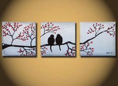 two birds sitting on a tree branch with red berries painted on it's sides