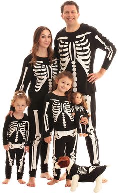 the family is dressed up in skeleton pajamas for halloween costumes, and they are all wearing matching outfits