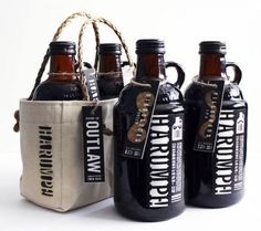 four bottles of beer are sitting next to each other in front of a canvas bag