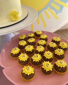 there are many cupcakes that have been placed on the pink plate with yellow frosting