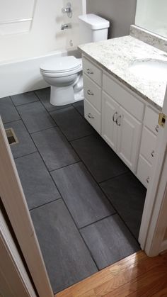 a white toilet sitting next to a bath tub in a bathroom