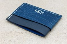 Introducing our exceptional luxury card wallet, meticulously crafted with a combination of blue American alligator and French chèvre leather, handstitched with waxed linen thread. This wallet embodies the perfect blend of opulence, durability, and unparalleled craftsmanship. Equipped with three pockets, this card wallet offers ample storage for your essential cards and folded bills. The wrap around pocket allows the leather to stretch, supplying extra room for cards and cash. Luxury Blue Card Holder For Gift, Luxury Blue Card Holder Gift, Luxury Blue Card Holder As Gift, Luxury Blue Leather Card Holder, Elegant Blue Bifold Card Holder, American Alligator, Linen Thread, Luxury Card, Extra Rooms