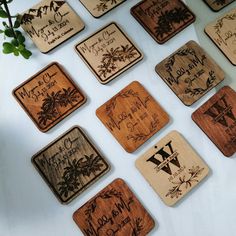 wooden coasters with names and pictures on them sitting on a white counter top next to a plant