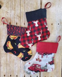 three christmas stocking hanging on a wooden wall with deer and firetruck designs