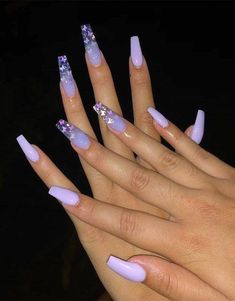 the woman is holding her hands with purple nails