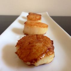 three pieces of food sitting on top of a white plate with sauce and banana slices