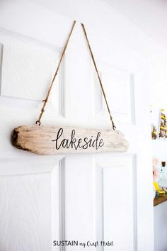 a wooden sign hanging from the side of a door that says lakesidee on it