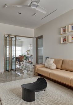 a living room with a couch, table and pictures on the wall