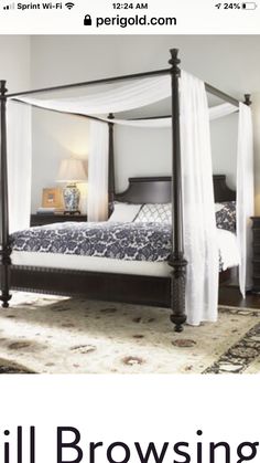 a four poster bed with white drapes over it