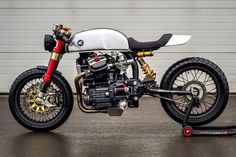 a white and black motorcycle parked in front of a garage