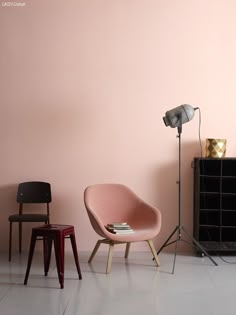 two chairs and a lamp in front of a pink wall