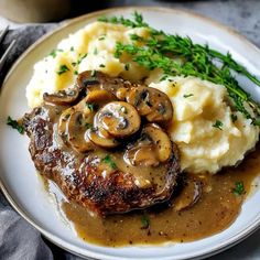 a white plate topped with mashed potatoes and mushrooms