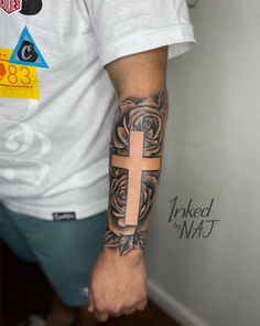 a man with a cross tattoo on his arm