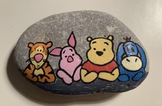 a rock with winnie the pooh and friends painted on it