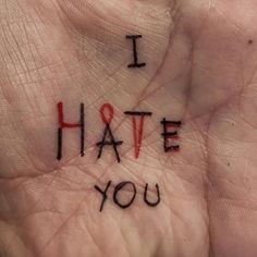 i hate you written on the palm of someone's hand with red writing in it