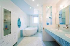 a bathroom with blue and white tile on the floor, tub, sink and mirror