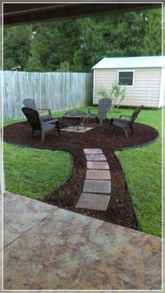 a backyard area with lawn chairs and gravel path leading to the back yard, covered in mulch