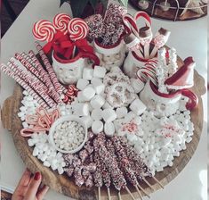 a wooden platter filled with lots of candy and lollipops on top of a table