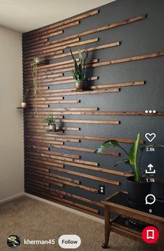 a living room with some plants on the wall and a wooden slat behind it