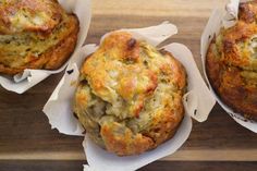 three muffins sitting on top of white paper wrapped in wax paper and placed next to each other