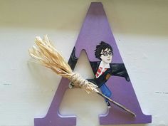 a wooden letter with a harry potter character on it and a broom in front of it