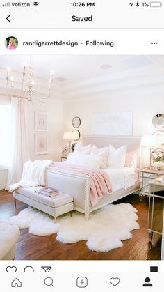 a bedroom with white bedding, chandelier and two tables in the corner