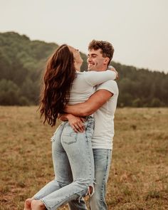 a man and woman hugging in an open field