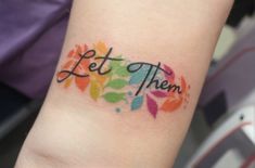 a colorful tattoo with the words let them go written in cursive writing on it