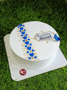 a birthday cake decorated with blue hearts and gold trimmings on the top of a white plate