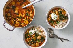 three bowls filled with stew, rice and spinach on top of a white table