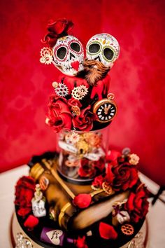 a cake decorated with red roses and skulls