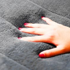 a woman's hand on top of a gray blanket