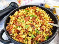 a skillet filled with corn and bacon