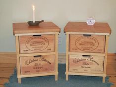 two wooden drawers with labels on them and a lit candle in the middle next to each drawer