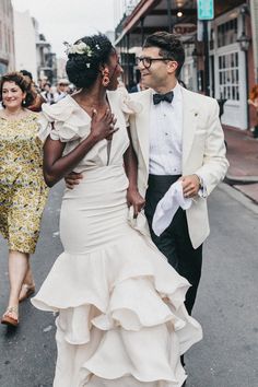 a bride and groom walking down the street