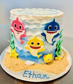 a birthday cake decorated with sharks and other sea creatures on top of the cake is made to look like sand