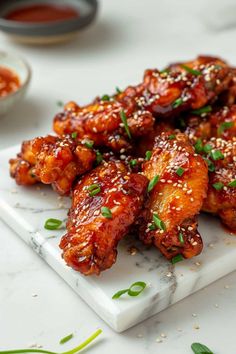 chicken wings with sesame seeds and seasoning on a white plate