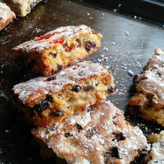 several pastries sitting on top of a pan covered in powdered sugar