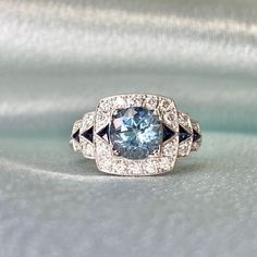 This item has just been reserved by another customer. Please contact us to be notified if it becomes available.  A magnificent 1.21-carat round-cut aquamarine is placed in prongs on a geometric gemstone ring. The aquamarine ring is flanked by a row of triangular French cut sapphires, which are also set on the stepped shoulders. Around the shoulders and set around the sapphires and aquamarine are round brilliant cut diamonds.  This ring contains roughly 0.45 carats of diamonds in total. The total Luxury Aquamarine Diamond Ring With Prong Setting, Elegant Gia Certified Blue Topaz Diamond Ring, Luxury Gia Certified Aquamarine Ring, Luxury Gia Certified Blue Topaz Rings, Gia Certified Round Art Deco Jewelry, Gia Certified Art Deco Round Jewelry, Luxury Gia Certified Round Topaz Ring, Luxury Gia Certified Topaz Ring, Luxury Light Blue Brilliant Cut Jewelry