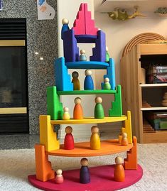 there is a colorful toy stacked on top of each other in front of a fireplace