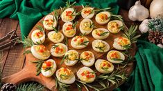 deviled eggs are arranged on a wooden platter